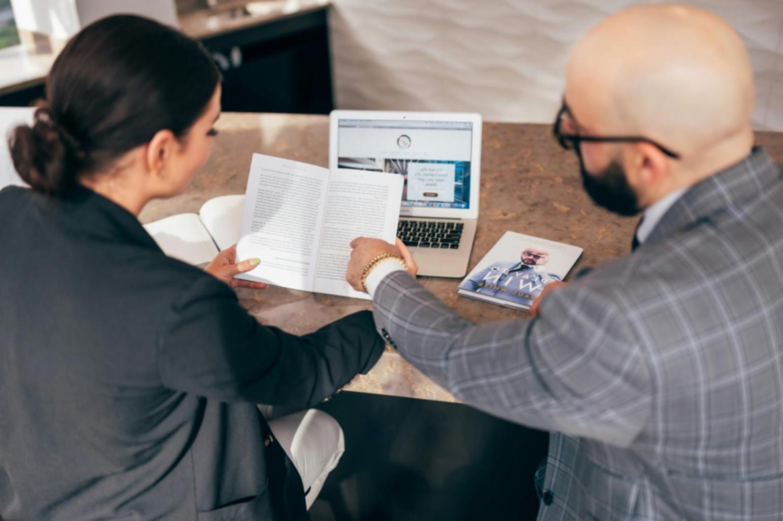 Beratungsgespräch zwischen Finanzexperte und Unternehmer am Schreibtisch